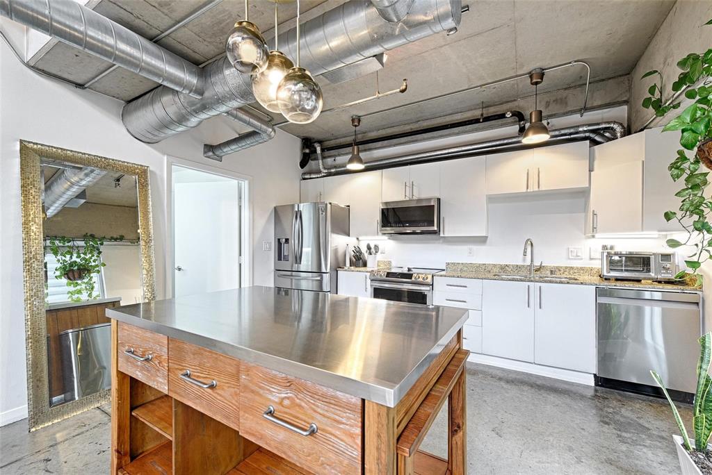 1001 Belleview Street, Unit 104 Dallas, TX 75215 - Photo 12 of 22 a kitchen with stainless steel appliances granite countertop a stove refrigerator and microwave
