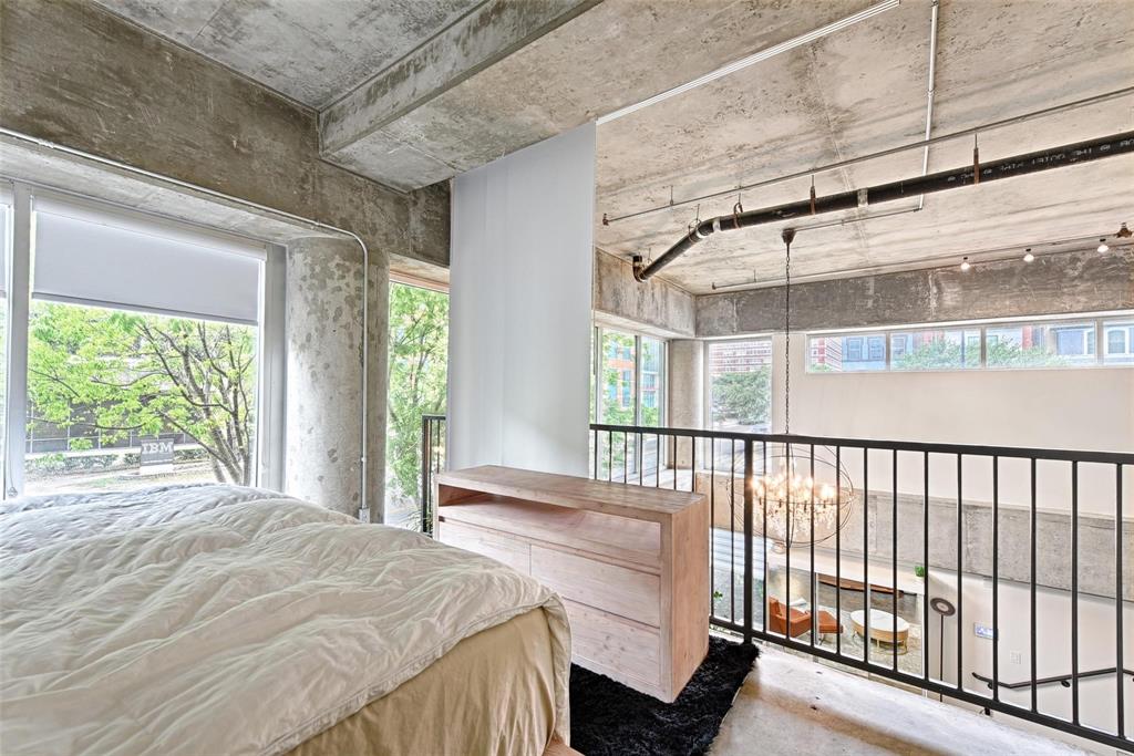 1001 Belleview Street, Unit 104 Dallas, TX 75215 - Photo 16 of 22 a bedroom with a bed and a large window with balcony view