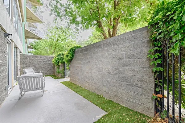 a view of a chair and table in backyard of the house