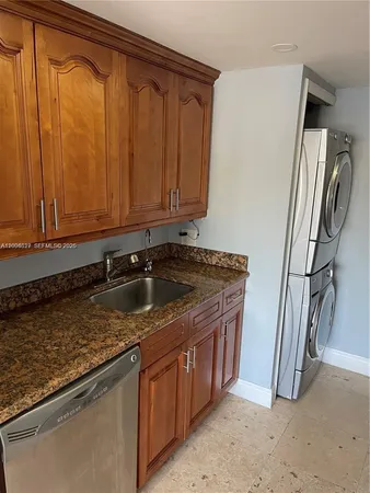 a kitchen with stainless steel appliances granite countertop a sink a stove and a refrigerator with wooden floor