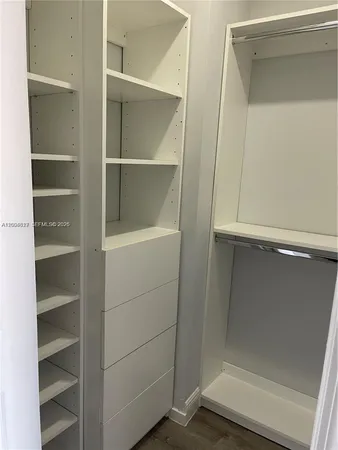 a view of walk in closet with empty racks