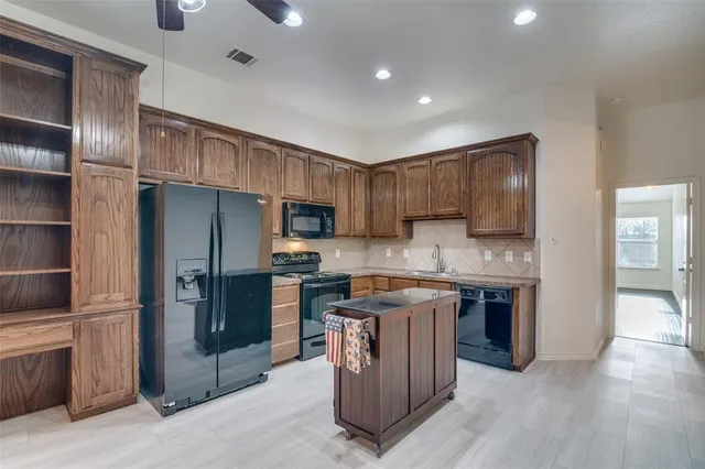 a kitchen with stainless steel appliances granite countertop a refrigerator stove and sink