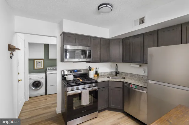 a kitchen with granite countertop a sink stove and refrigerator