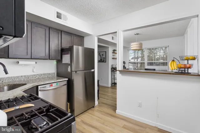 a kitchen with stainless steel appliances granite countertop a refrigerator and a stove