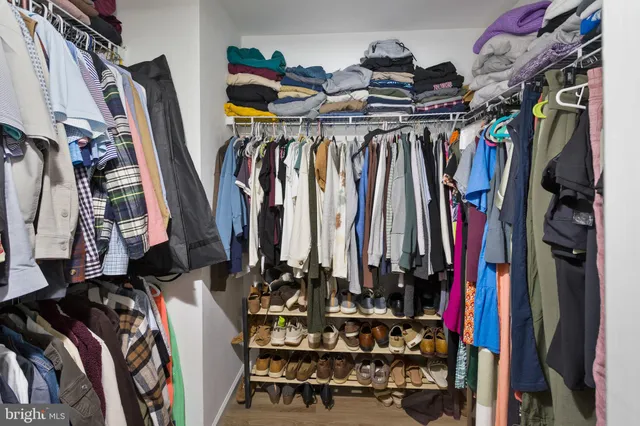 a view of walk in closet with clothes and shoes