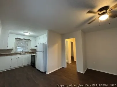 a view of a kitchen with a sink and dishwasher a refrigerator with wooden floor
