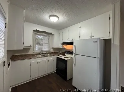 a kitchen with a sink a refrigerator a stove a microwave and cabinets