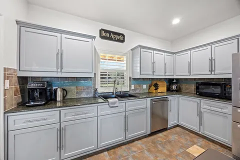 a kitchen with white cabinets and white appliances