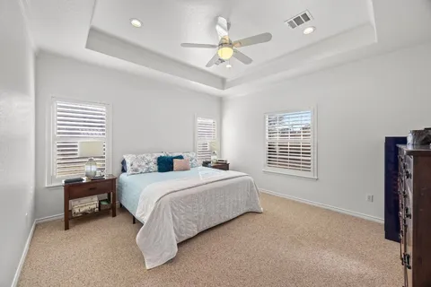 a spacious bedroom with a bed and a chandelier