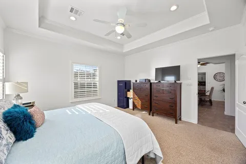 a bedroom with a bed dresser and a chandelier