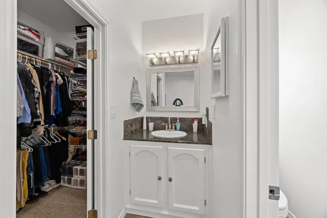 a view of walk in closet with clothes