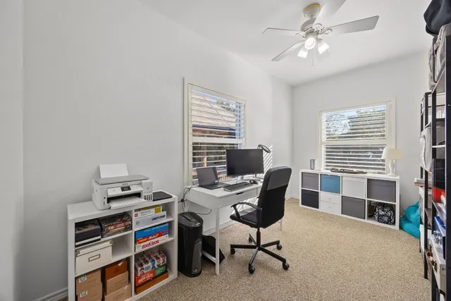 a view of a workspace with furniture and a window
