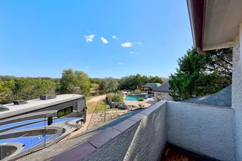 a view of a balcony with chairs and wooden fence