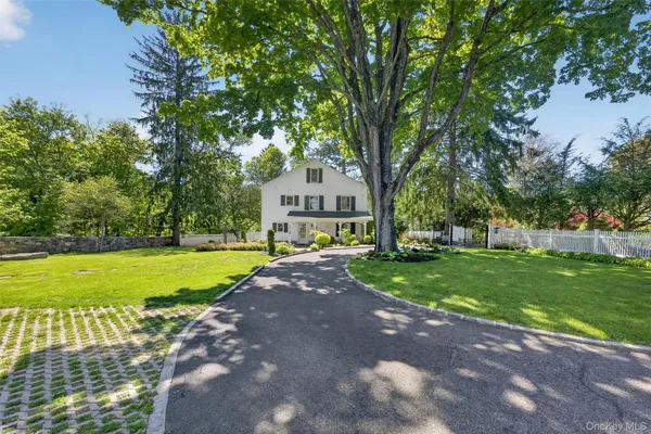 a front view of a house with a yard and trees