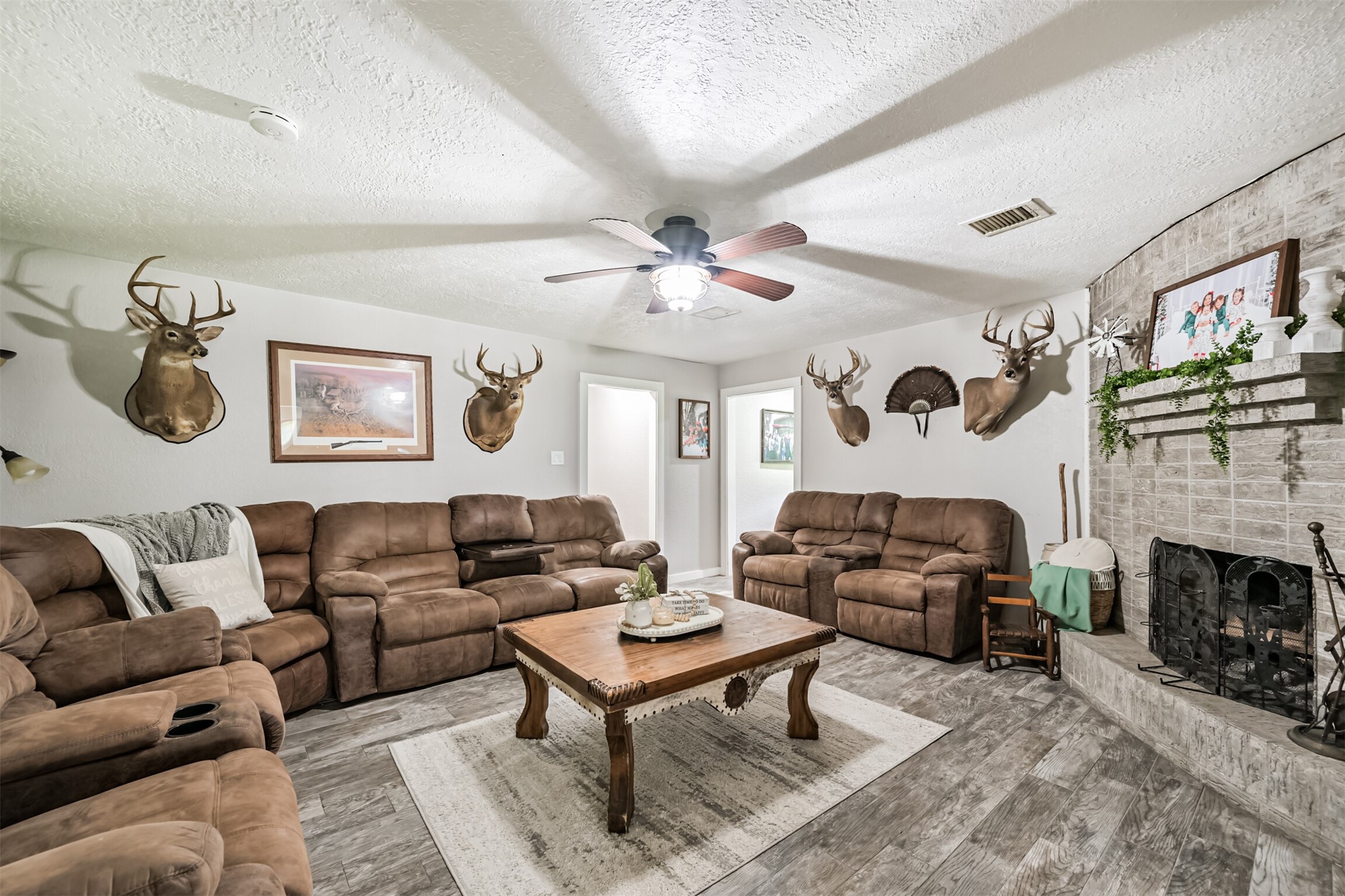 26925 Brentwood Road Splendora, TX 77372 - Photo 14 of 30 a living room with furniture a fireplace and a ceiling fan