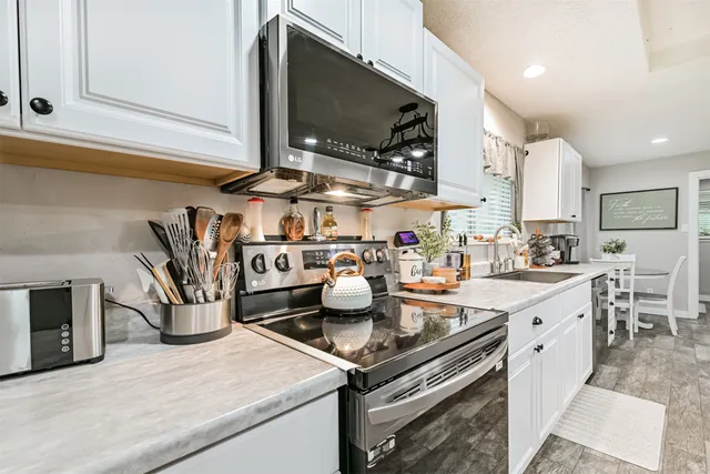 a kitchen with stainless steel appliances granite countertop a sink and a stove