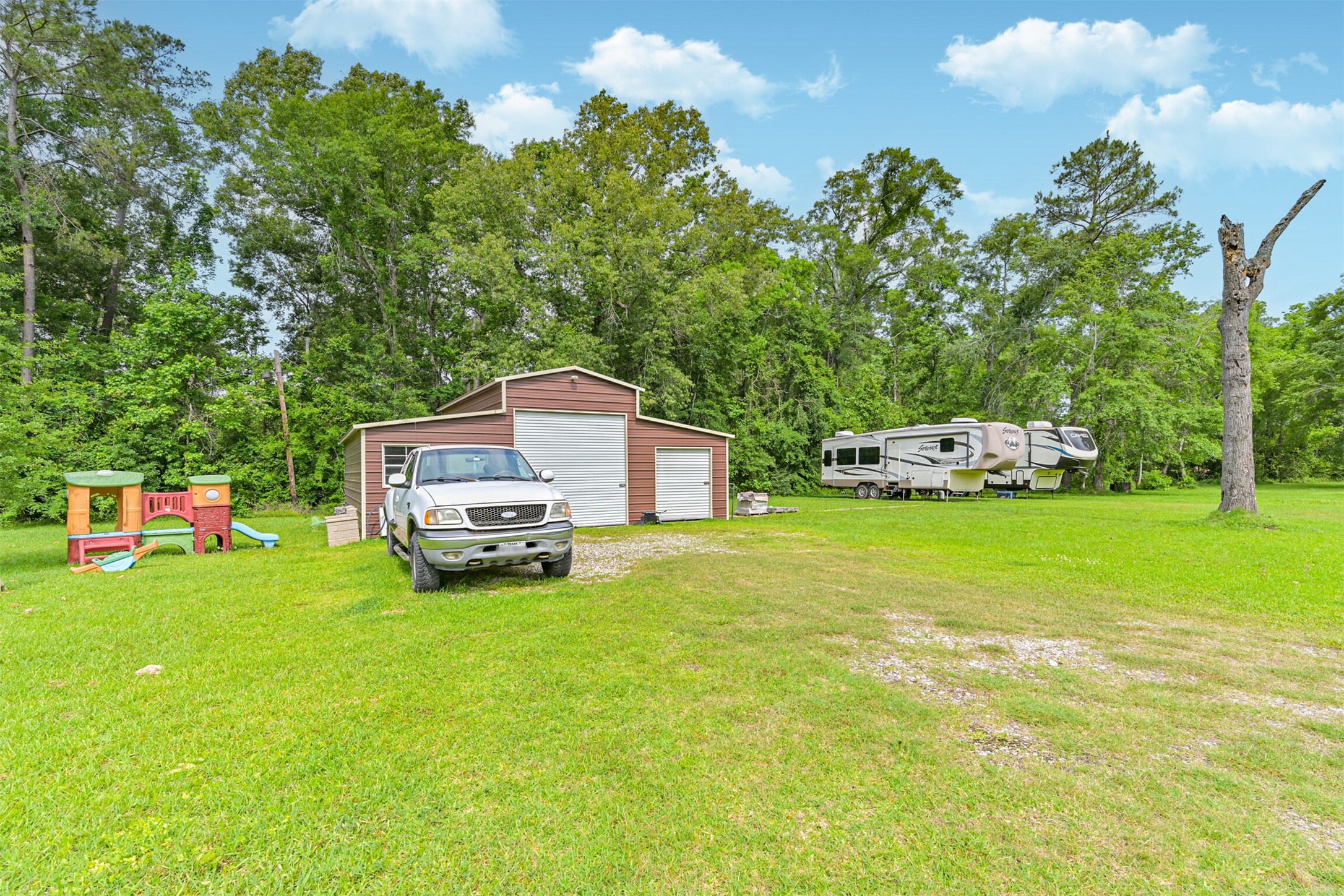 26925 Brentwood Road Splendora, TX 77372 - Photo 2 of 30 a car parked in front of a house with a small yard
