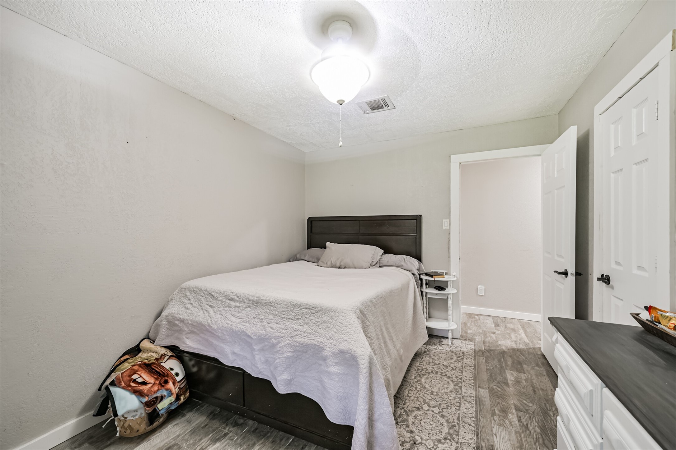 26925 Brentwood Road Splendora, TX 77372 - Photo 25 of 30 a bedroom with a bed and a chandelier