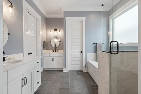 a en suite bathroom with a double vanity sink a mirror and a bathtub
