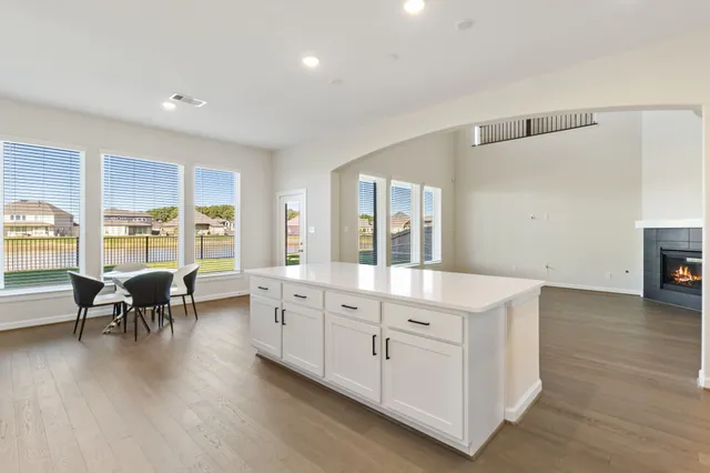 a large white kitchen with sink and dishwasher a stove with wooden floor