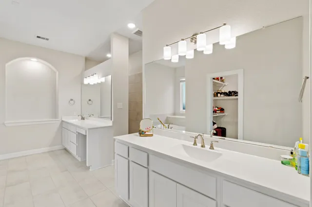 a bathroom with a sink a vanity a large mirror and shower