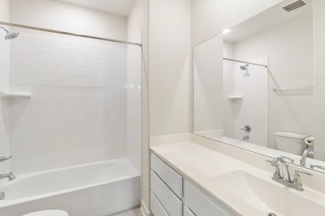 a bathroom with a granite countertop sink and a bathtub