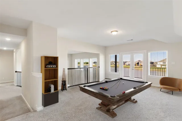 a living room with furniture pool table and refrigerator