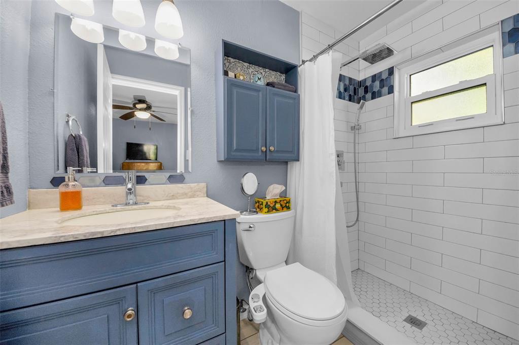 8037 Powder Horn Circle Largo, FL 33773 - Photo 12 of 27 a bathroom with a granite countertop toilet sink and mirror