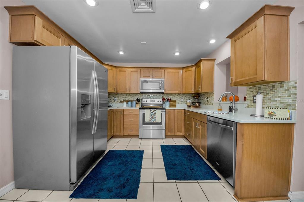8037 Powder Horn Circle Largo, FL 33773 - Photo 6 of 27 a kitchen with stainless steel appliances granite countertop a refrigerator sink and cabinets
