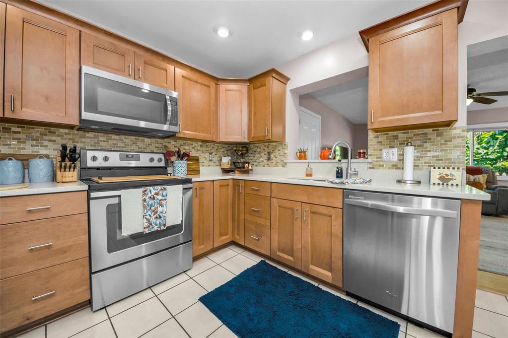 8037 Powder Horn Circle Largo, FL 33773 - Photo 7 of 27 a kitchen with stainless steel appliances granite countertop a stove sink and cabinets
