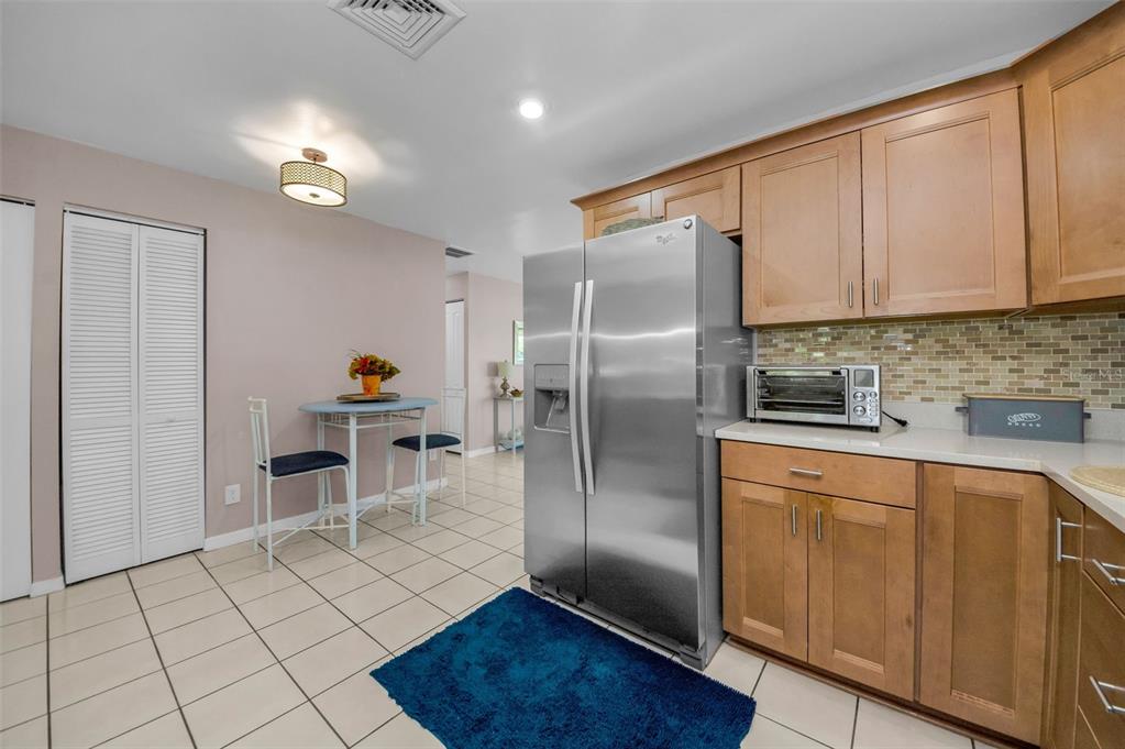 8037 Powder Horn Circle Largo, FL 33773 - Photo 8 of 27 a kitchen with stainless steel appliances granite countertop a refrigerator a sink a stove and white cabinets