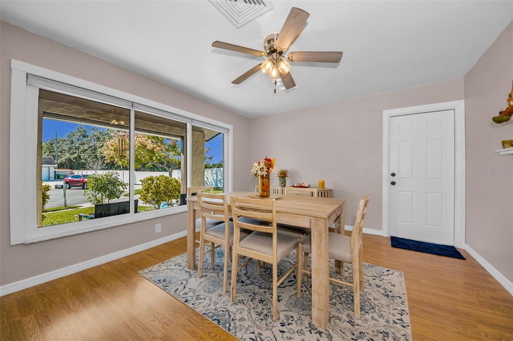 8037 Powder Horn Circle Largo, FL 33773 - Photo 9 of 27 a view of a dining room with furniture window and wooden floor