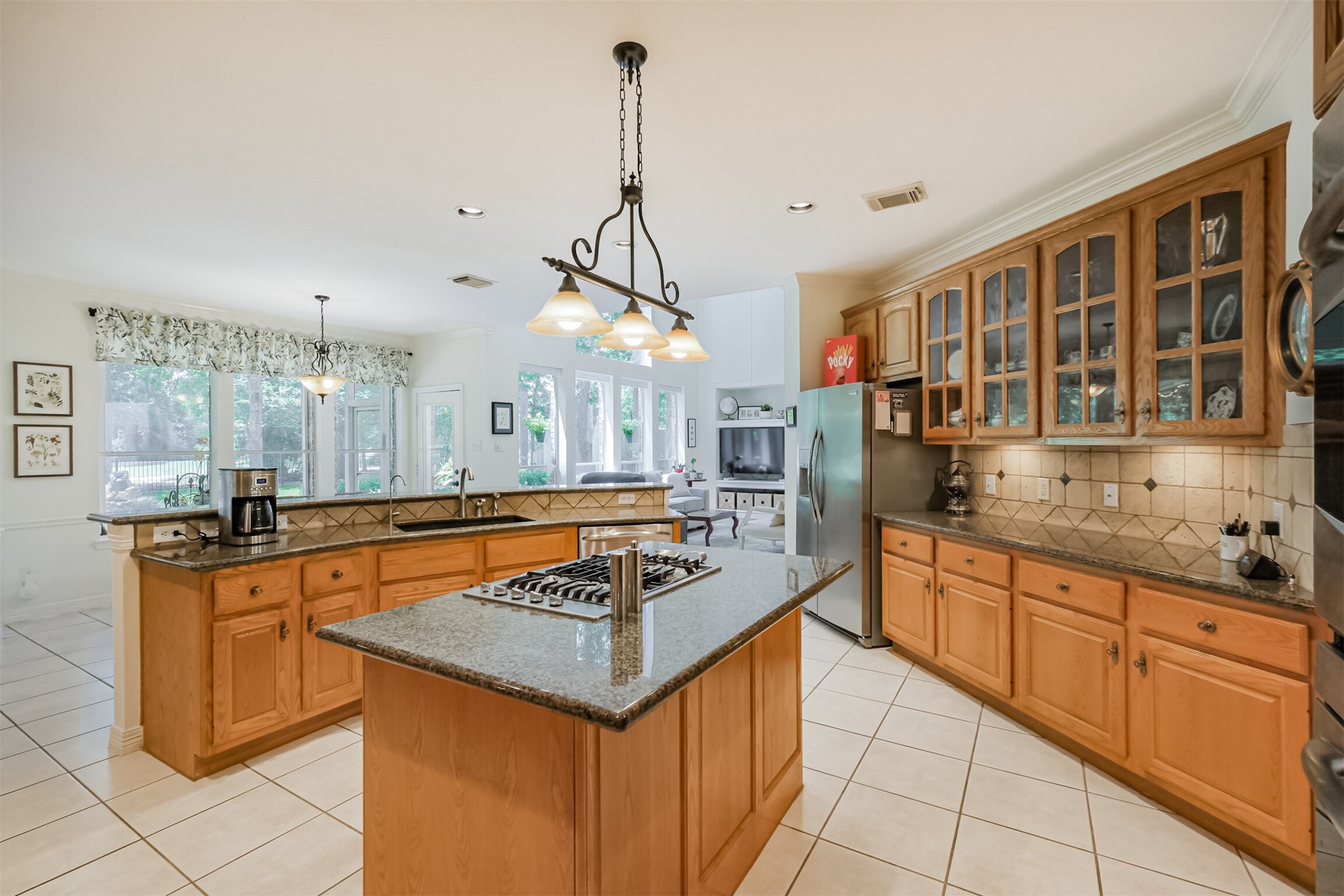 14919 Codys Run Cypress, TX 77429 - Photo 5 of 32 Designed with both everyday living and entertaining in mind, the spacious kitchen features abundant cabinet and counter space, a center island with gas cooktop, and a breakfast bar that keeps everyone connected. Open sightlines to the family room, breakfast area, and backyard make it easy to stay part of the conversation while preparing meals.
