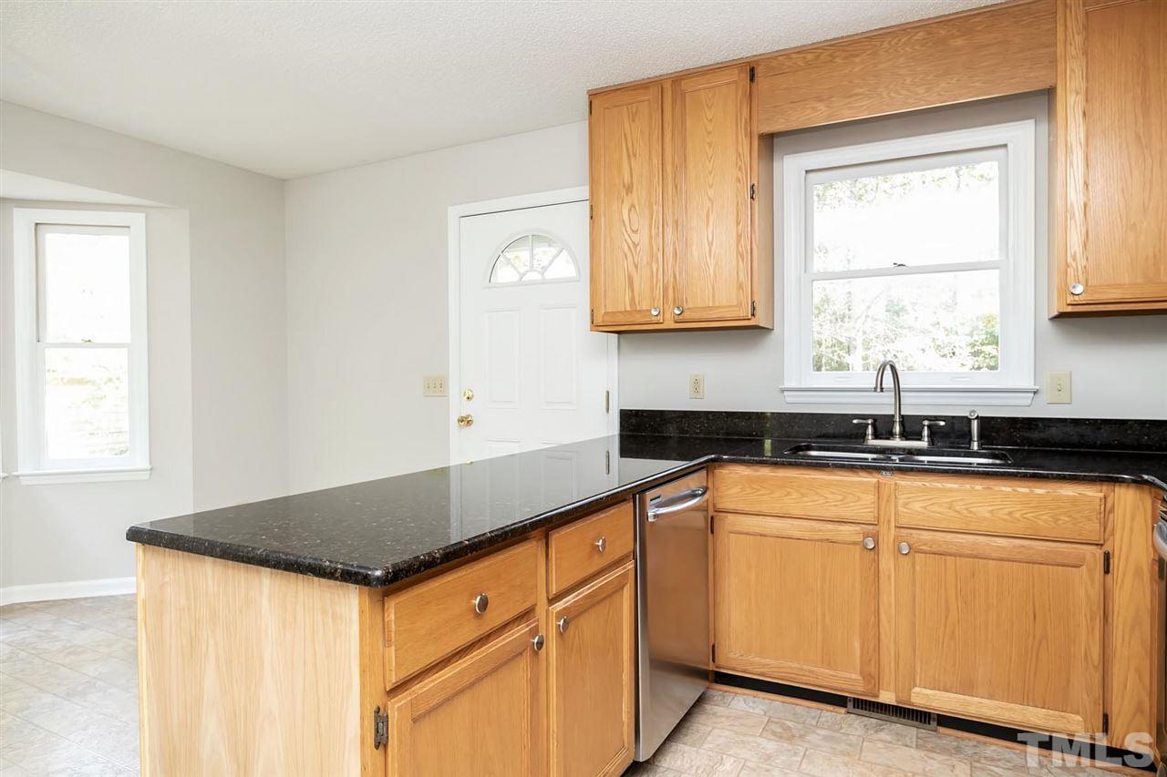 5209 Relay Way Raleigh, NC 27603 - Photo 14 of 25 a kitchen with granite countertop white cabinets and white appliances