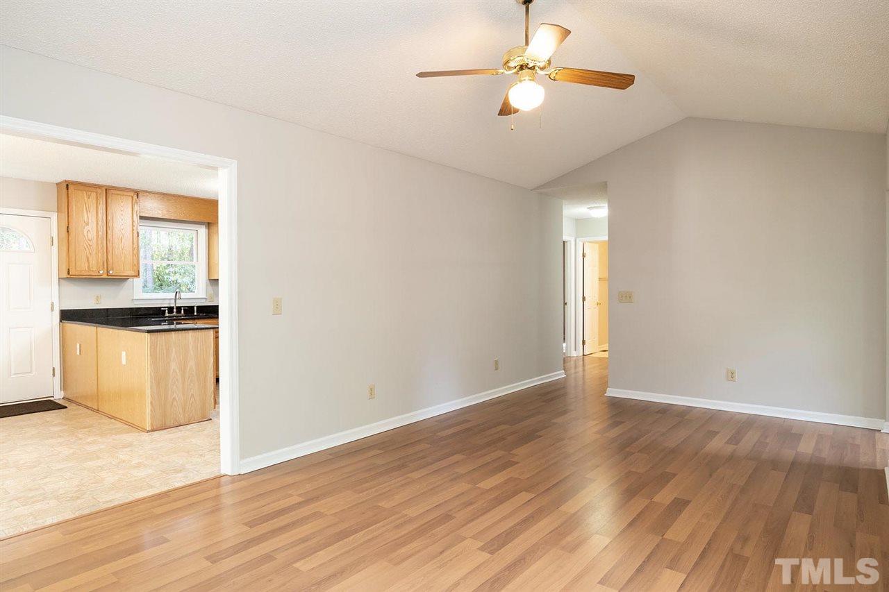 5209 Relay Way Raleigh, NC 27603 - Photo 8 of 25 an empty room with wooden floor chandelier fan and windows