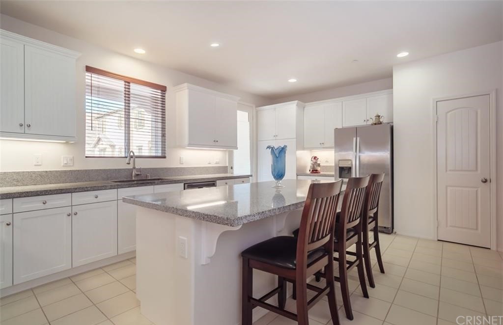 22166 Barrington Way Saugus, CA 91350 - Photo 4 of 19 a kitchen with granite countertop cabinets stainless steel appliances a sink and a window