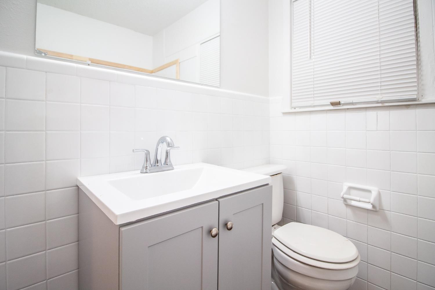 5105 39th Street Lubbock, TX 79414 - Photo 15 of 18 a bathroom with a sink a toilet and a mirror
