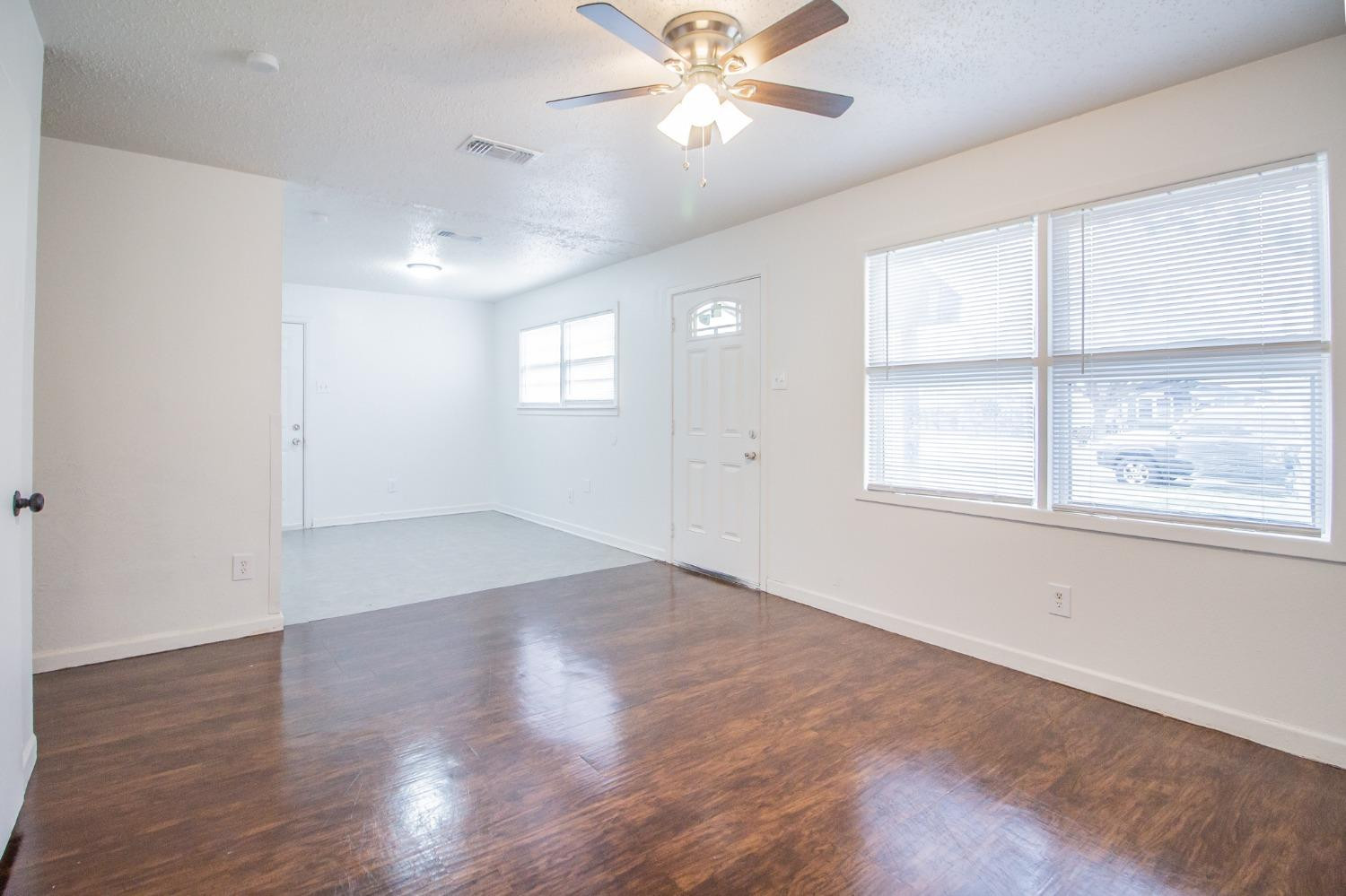 5105 39th Street Lubbock, TX 79414 - Photo 4 of 18 an empty room with wooden floor and windows