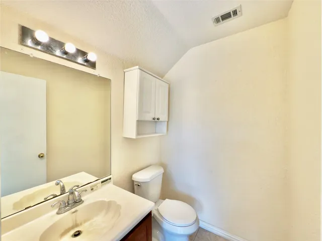 a bathroom with a sink mirror and toilet