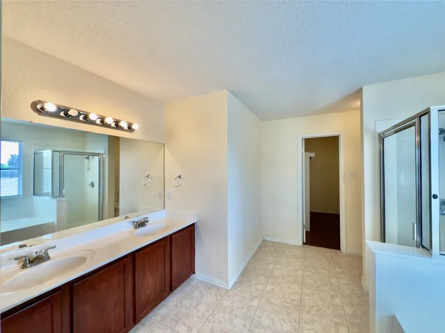 a spacious bathroom with a double vanity sink and a mirror