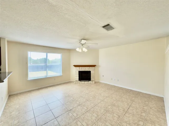 an empty room with windows and fireplace