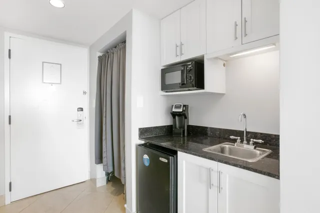 a kitchen with stainless steel appliances granite countertop a sink a stove and a refrigerator