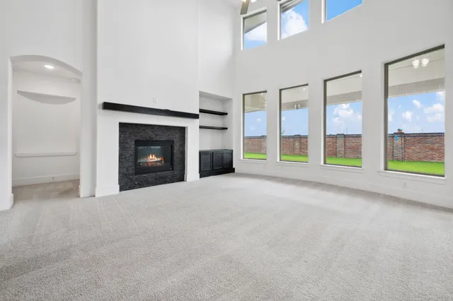 a view of an empty room with a fireplace and a window