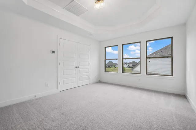 an empty room with a window and closet
