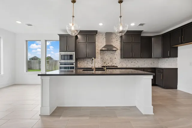 a kitchen with stainless steel appliances granite countertop a sink a refrigerator and a counter top space