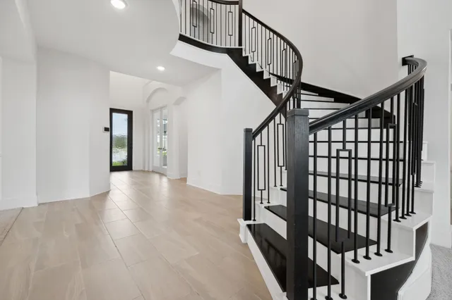a view of staircase with lots of frames on wall and wooden floor
