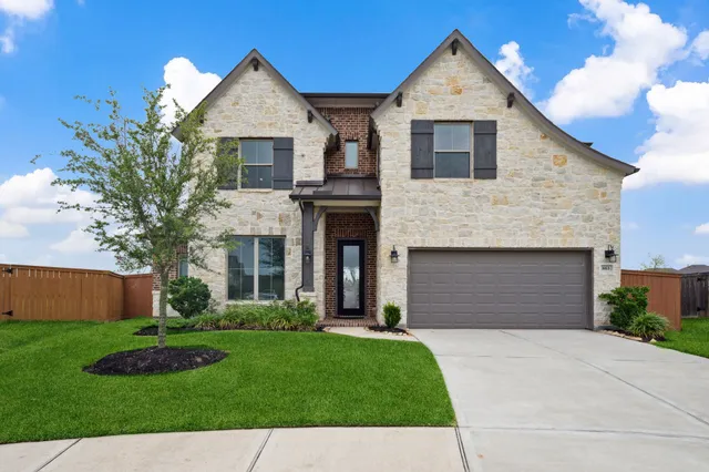 a front view of a house with a garden and plants