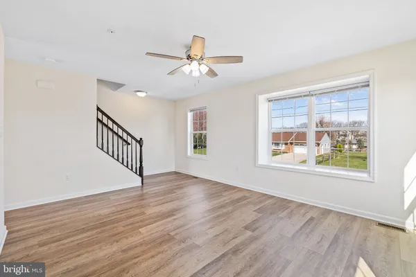 an empty room with a ceiling fan and a window