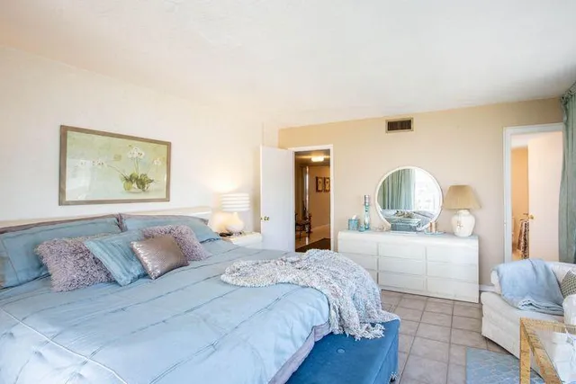 a bedroom with a large bed and a painting