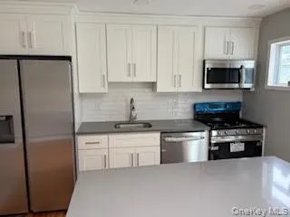 a kitchen with stainless steel appliances granite countertop a refrigerator a stove a sink and a microwave